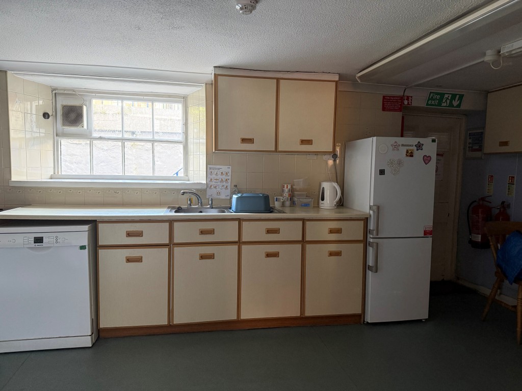 Lot: 129 - COMMERCIAL PROPERTY FOR UPDATING WITH PARKING AND OFFERING POTENTIAL - Lower ground floor kitchen with access to front of the property